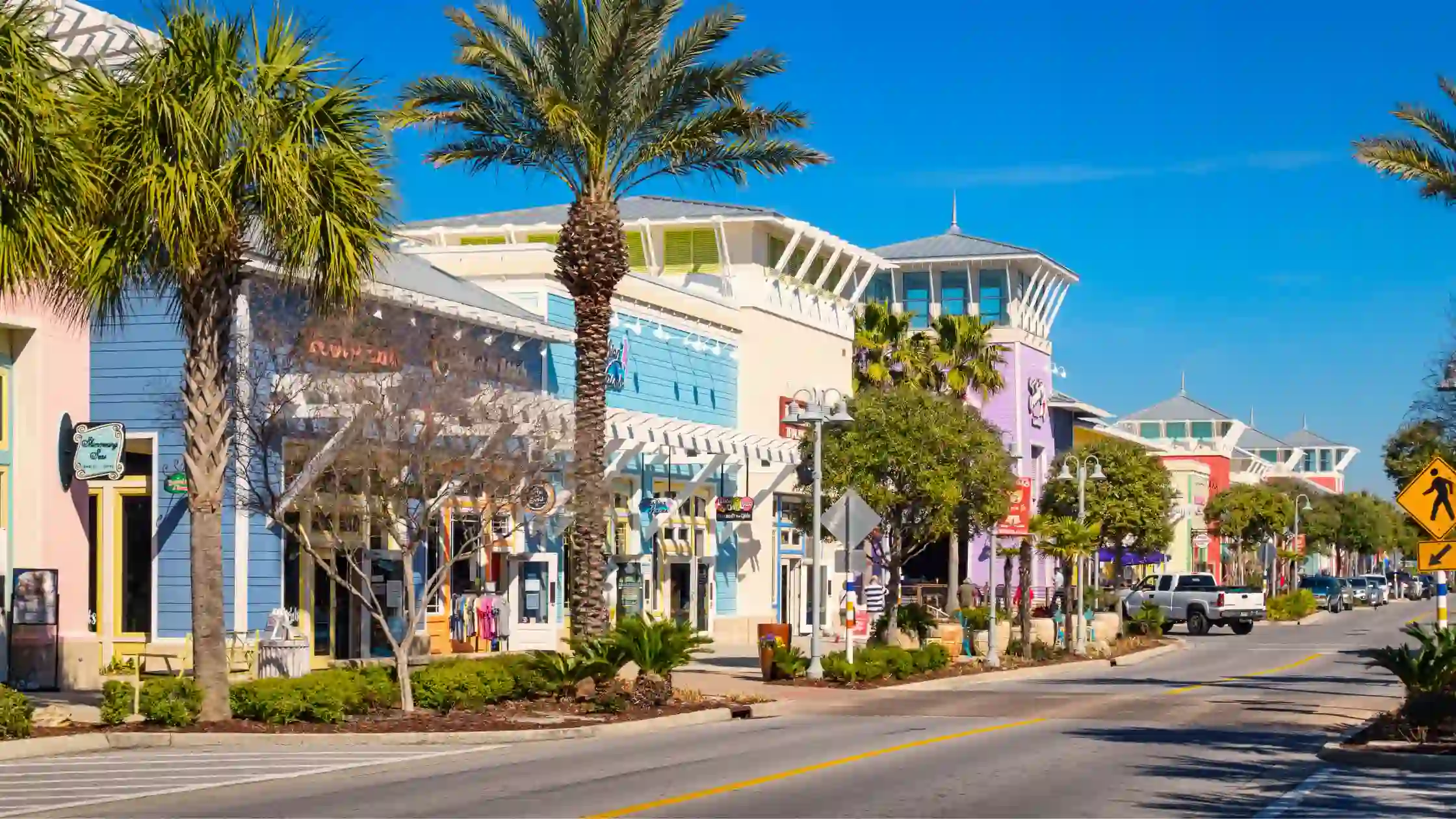 Tropical shops line the street under clear Weather in South Florida skies.